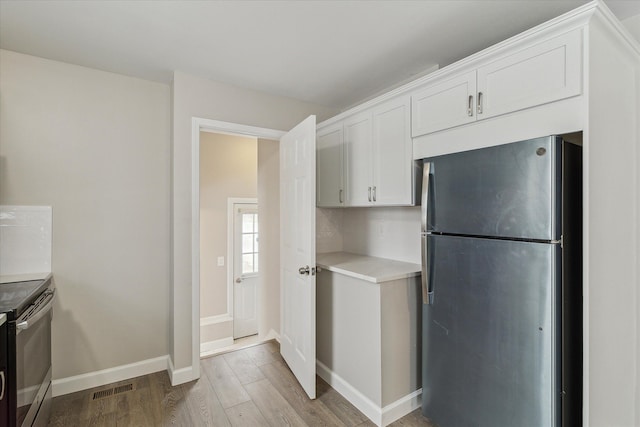 kitchen featuring white cabinetry, appliances with stainless steel finishes, and light hardwood / wood-style flooring