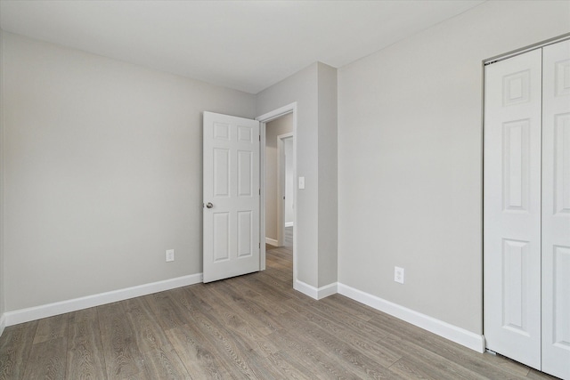 unfurnished bedroom featuring light wood-type flooring and a closet