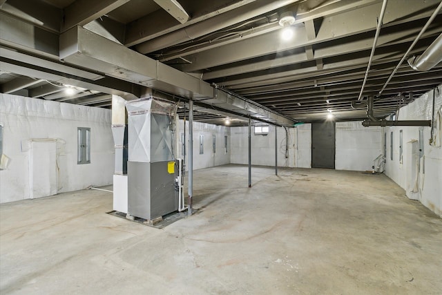 basement featuring electric panel and heating unit