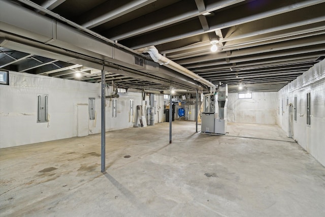 basement featuring electric panel and heating unit