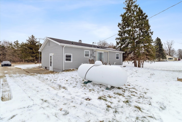 view of snow covered rear of property