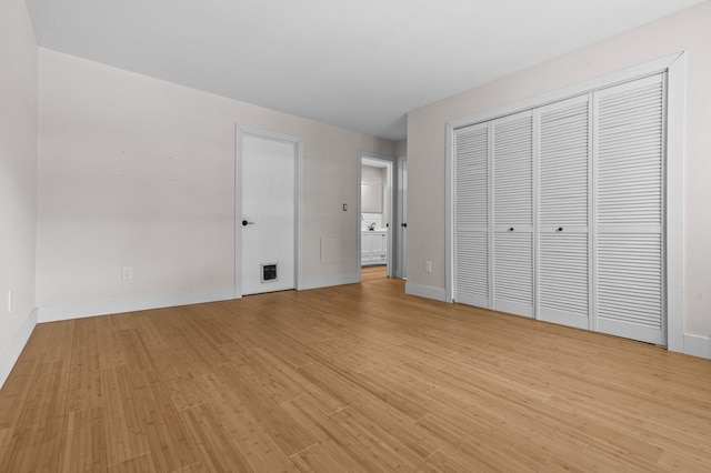 unfurnished bedroom featuring a closet and light hardwood / wood-style flooring