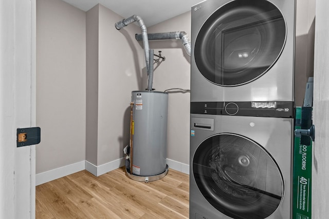 clothes washing area featuring light hardwood / wood-style flooring, stacked washer / drying machine, and gas water heater