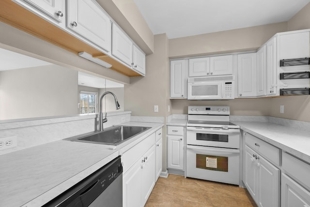 kitchen with white cabinets, white appliances, and sink