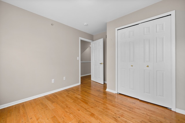 unfurnished bedroom with a closet and light hardwood / wood-style floors