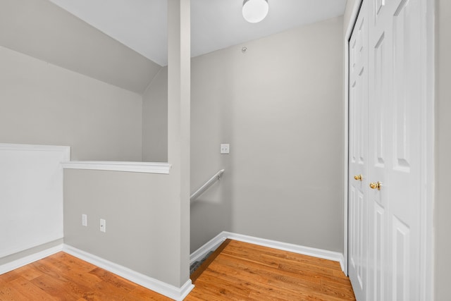 hallway featuring wood-type flooring and vaulted ceiling