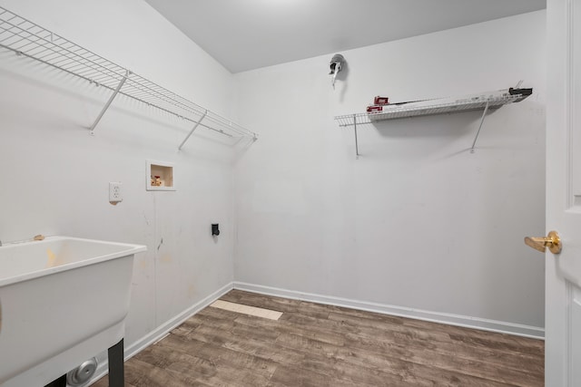 washroom featuring electric dryer hookup, dark hardwood / wood-style floors, sink, and hookup for a washing machine