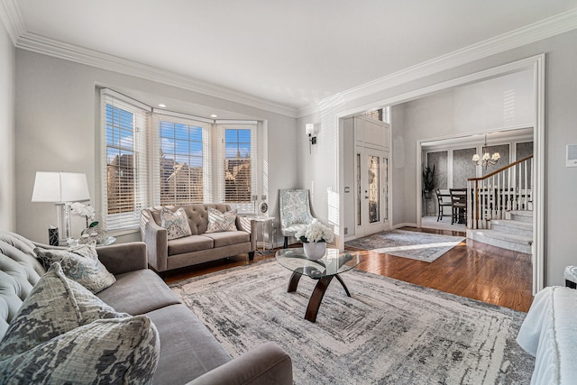 living room featuring hardwood / wood-style flooring, ornamental molding, and a chandelier