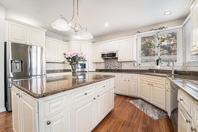 kitchen featuring pendant lighting, a center island, white cabinets, appliances with stainless steel finishes, and sink