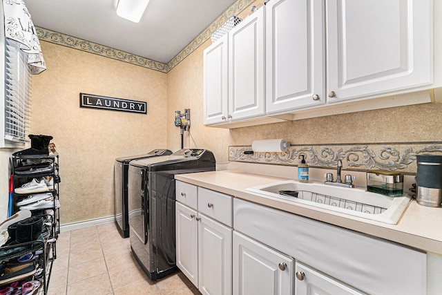 clothes washing area featuring sink, light tile patterned floors, separate washer and dryer, and cabinets