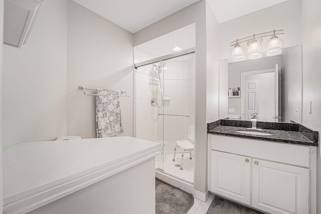 bathroom with a shower with door, vanity, and tile patterned flooring