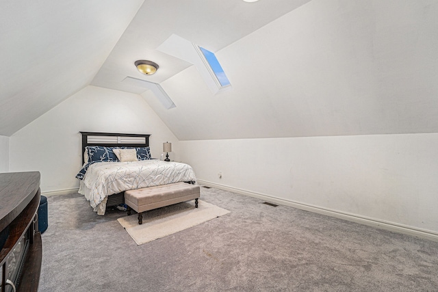 carpeted bedroom with vaulted ceiling with skylight