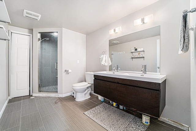 bathroom featuring toilet, a shower with shower door, and vanity