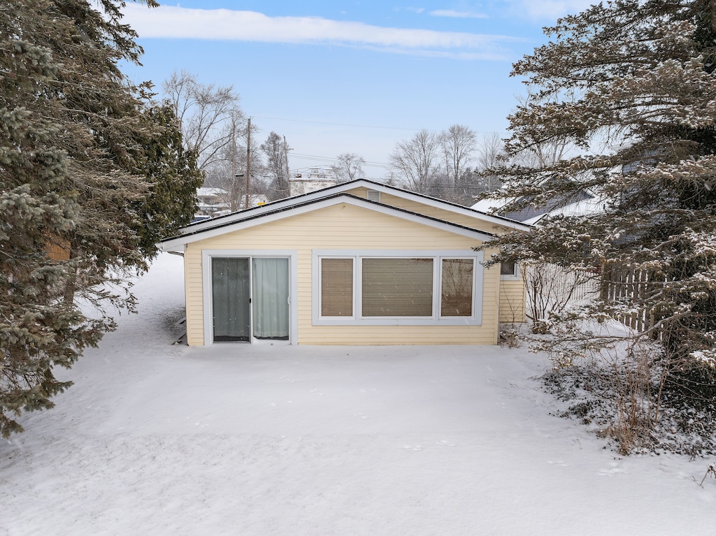 view of snow covered back of property