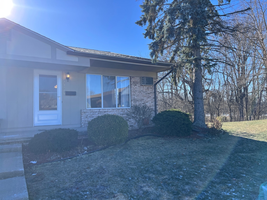 entrance to property with a lawn