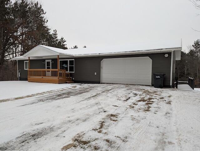 single story home with a porch and a garage