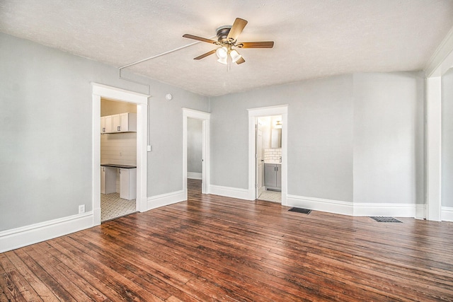 unfurnished bedroom with hardwood / wood-style floors, ceiling fan, a textured ceiling, and ensuite bath