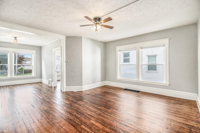 spare room with hardwood / wood-style floors, ceiling fan, a textured ceiling, and a wealth of natural light