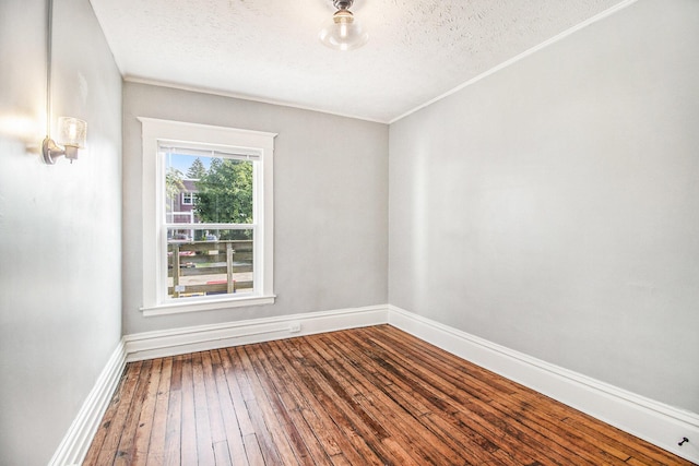 unfurnished room with wood-type flooring and a textured ceiling