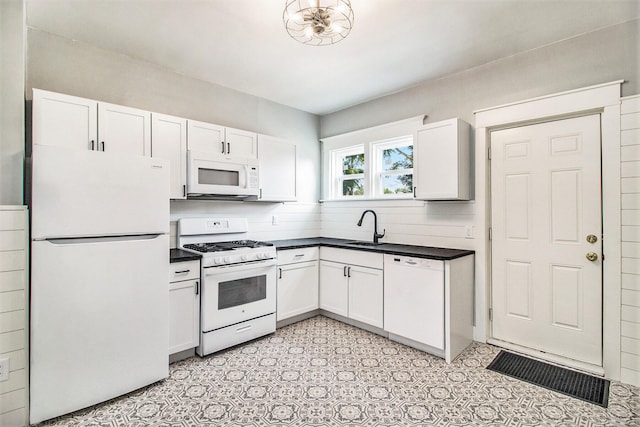 kitchen with white cabinetry, white appliances, and sink