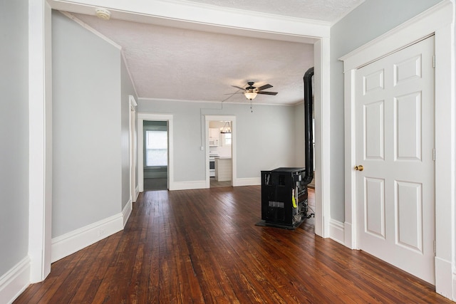 unfurnished living room featuring a textured ceiling, ceiling fan, dark hardwood / wood-style floors, and ornamental molding