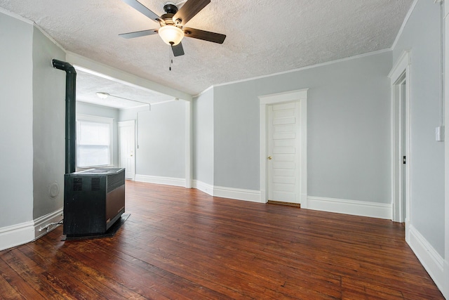 empty room with ceiling fan, dark hardwood / wood-style flooring, heating unit, a textured ceiling, and ornamental molding