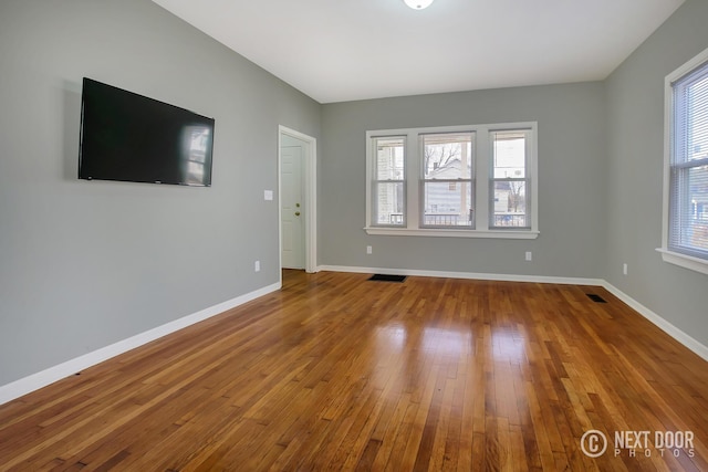 unfurnished living room with hardwood / wood-style floors and a healthy amount of sunlight