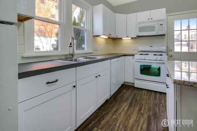 kitchen with white cabinets, dark hardwood / wood-style flooring, white appliances, and sink