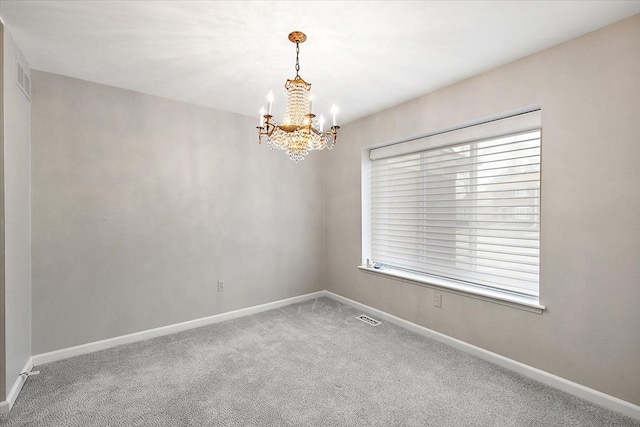 empty room with carpet and an inviting chandelier