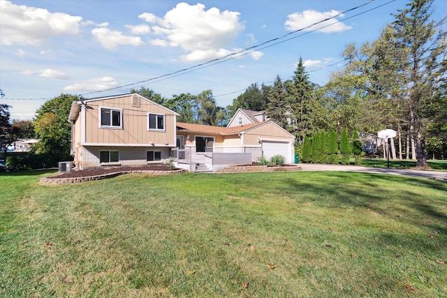 view of front of home with cooling unit, a front lawn, and a garage