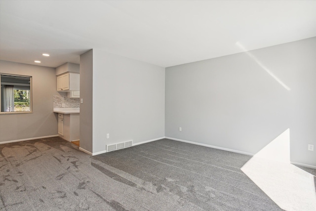 unfurnished living room with dark colored carpet