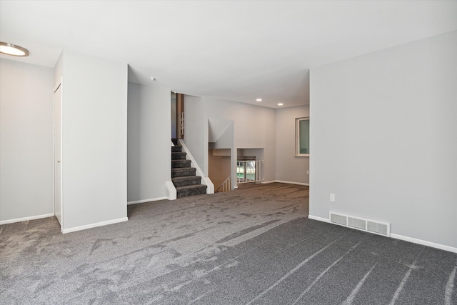 unfurnished living room with dark carpet