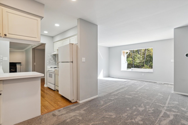 kitchen with decorative backsplash, light carpet, a fireplace, and white appliances