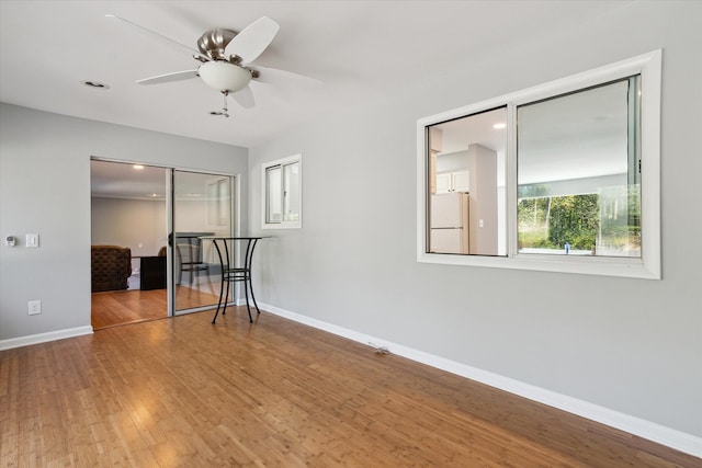 spare room with hardwood / wood-style floors and ceiling fan