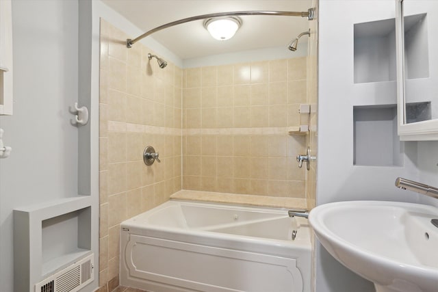 bathroom featuring tiled shower / bath and sink