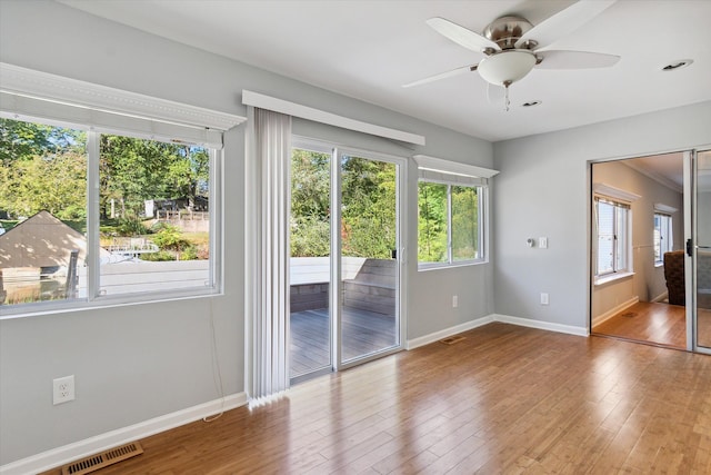 interior space with ceiling fan, wood-type flooring, and a wealth of natural light