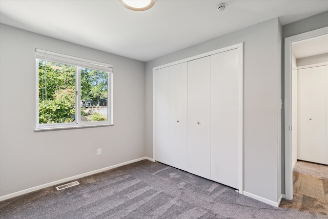 unfurnished bedroom featuring carpet flooring and a closet