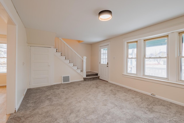 foyer entrance with light colored carpet