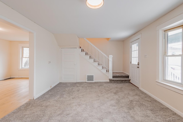 foyer featuring light carpet