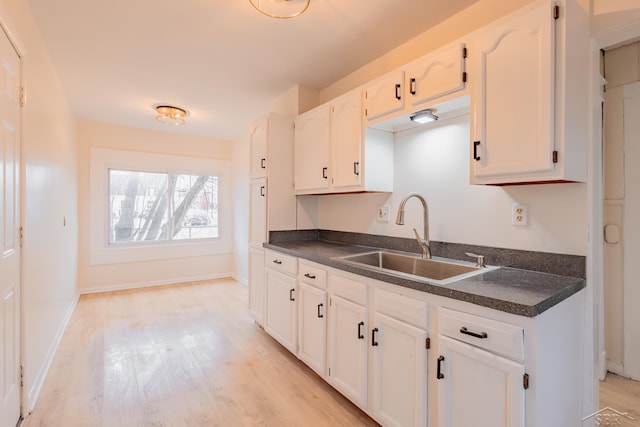 kitchen featuring light hardwood / wood-style floors, white cabinetry, and sink