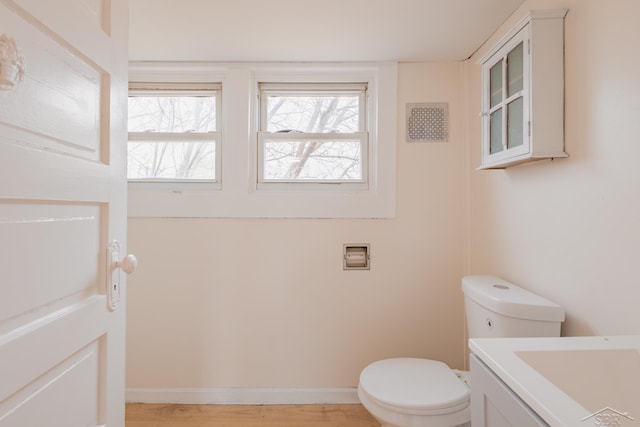 bathroom with toilet, vanity, and hardwood / wood-style flooring