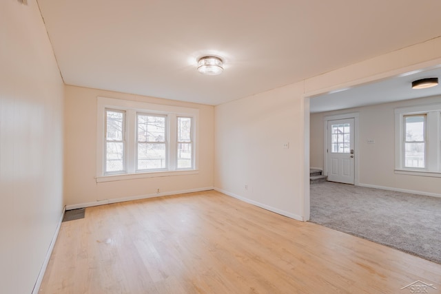 spare room featuring light carpet