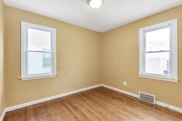 unfurnished room with hardwood / wood-style flooring