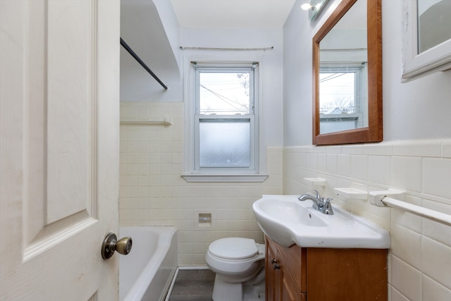 bathroom with tile walls, toilet, a bath, and vanity