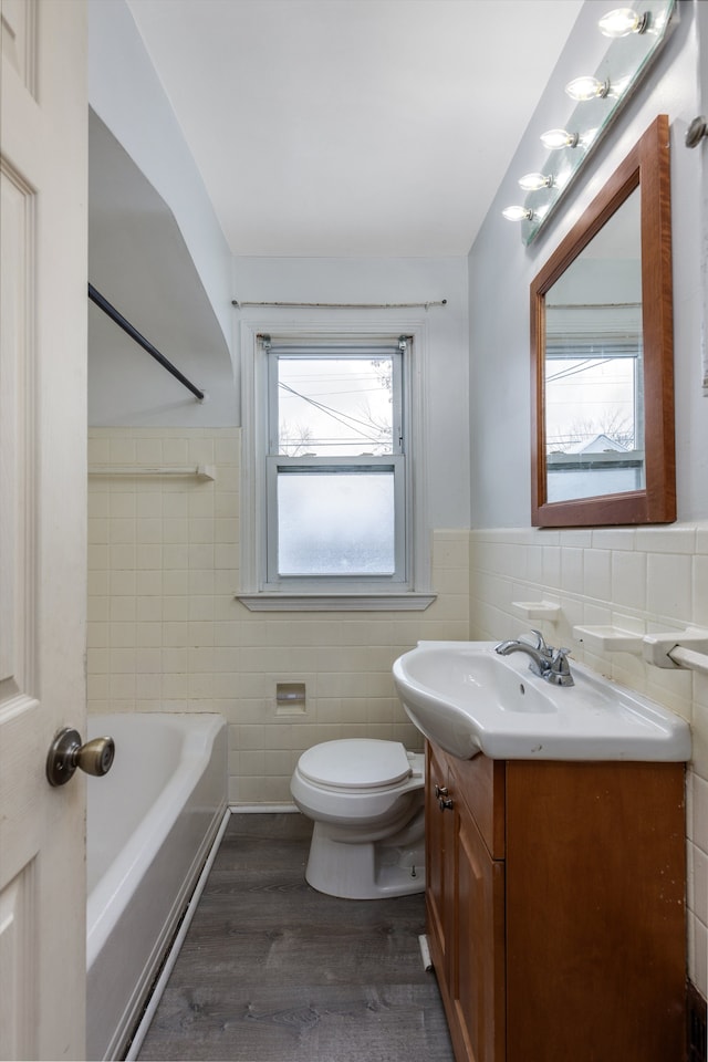 full bathroom featuring toilet, hardwood / wood-style flooring, tile walls, shower with separate bathtub, and vanity