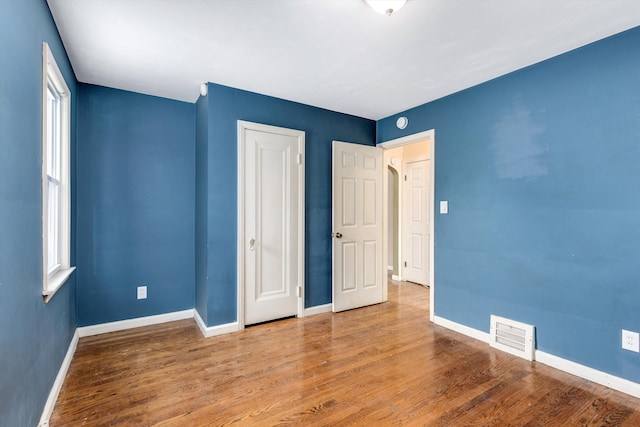 unfurnished bedroom featuring a closet and wood-type flooring