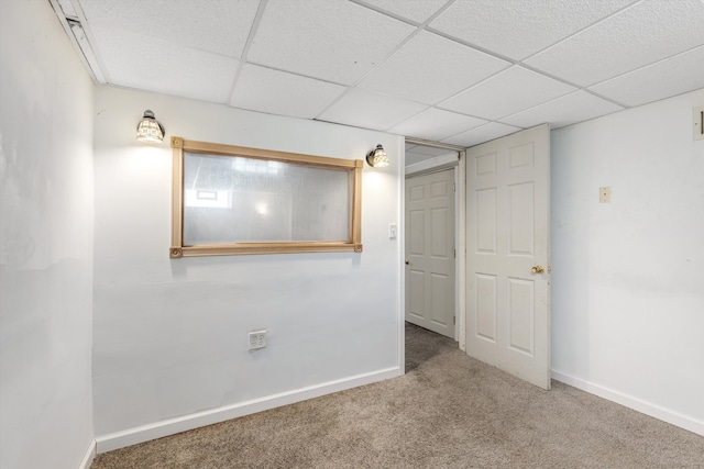 carpeted spare room with a drop ceiling