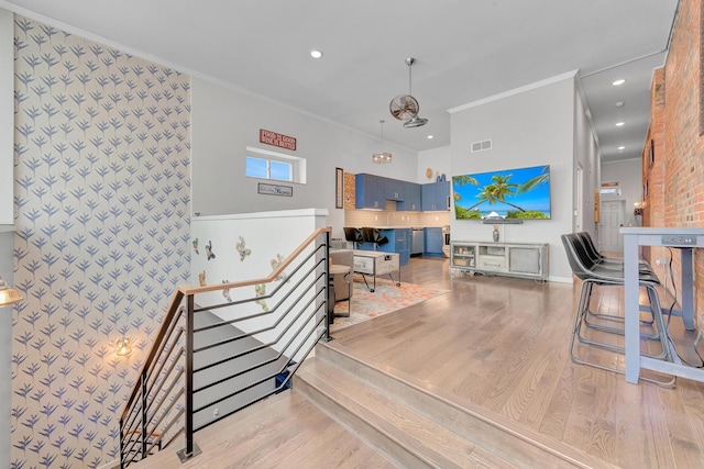 interior space featuring light wood-type flooring and crown molding