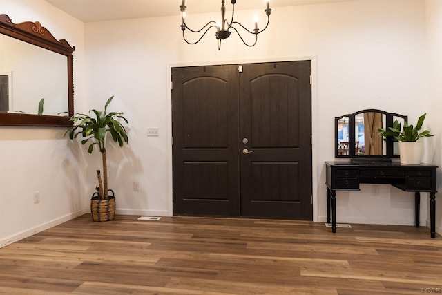 foyer entrance with a chandelier and hardwood / wood-style flooring