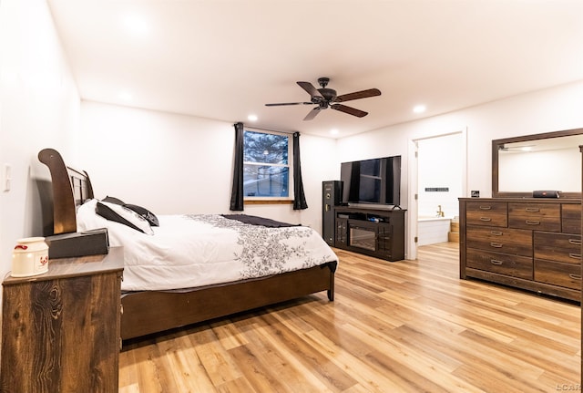 bedroom featuring ceiling fan, ensuite bathroom, and light wood-type flooring